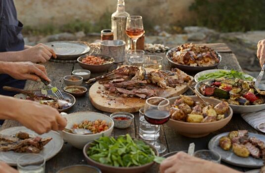 Grande tablée familiale garnie de viandes grillées, de poulet, de légumes et de pommes de terre à partager
