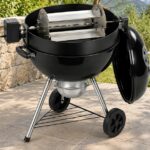 Panier rôtissoire Grill à Papa à quatre plateaux installé sur un barbecue kettle de 57 cm équipé d’un kit rôtissoire.