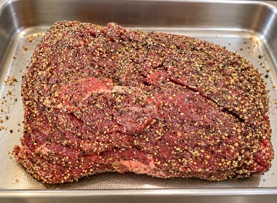 Rôti de bœuf cru assaisonné de sel et de mélange 5 Baies de Papa avant sa cuisson au four
