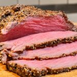 Rôti de bœuf froid au 5 Baies de Papa, découpé en fines tranches sur une planche en bois