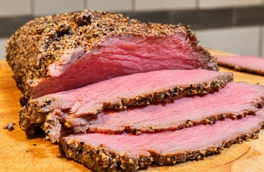Rôti de bœuf froid au 5 Baies de Papa, découpé en fines tranches sur une planche en bois