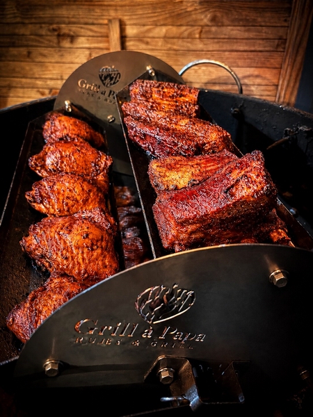Ribs et morceaux de poulet en cuisson sur le panier multi-plateaux Grill à Papa
