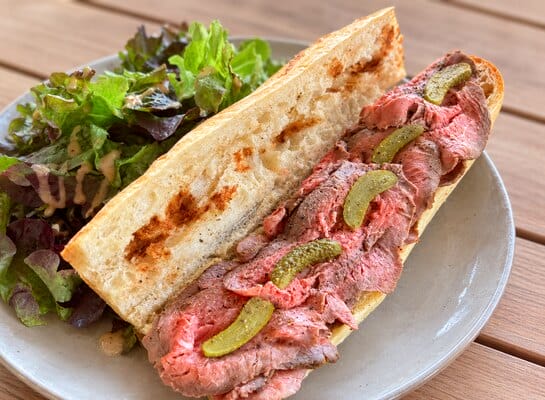 Sandwich garni de fines tranches de rôti de bœuf froid au 5 Baies de Papa avec salade et cornichons