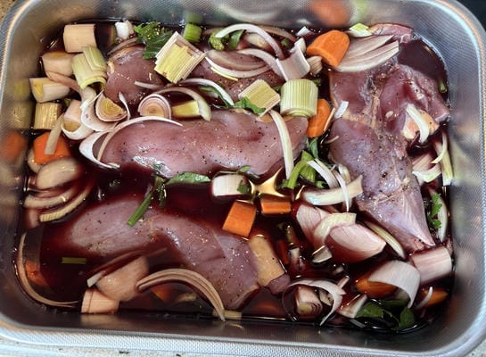 Faisan sans peau et légumes qui marinent dans le vin rouge avant la cuisson
