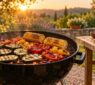 Courgettes, poivrons et maïs sur un barbecue rond dans un jardin au coucher du soleil.